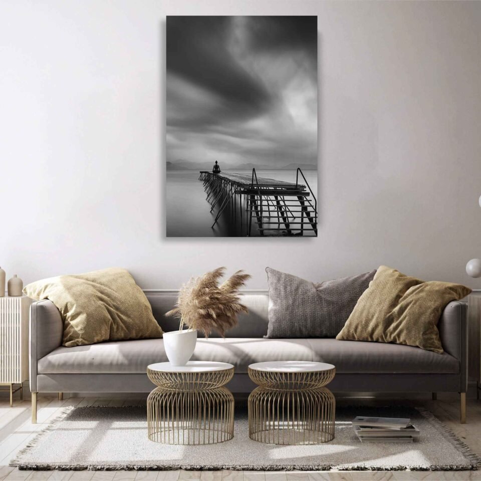 Meditation on The Pier - Spiritual Wall Art. The stark contrast between light and shadow adds a dramatic element to the composition, emphasizing the stillness and introspection of the meditation practice. Printed with meticulous attention to detail, our Canvas Print beautifully showcases the depth and texture of the original photograph.