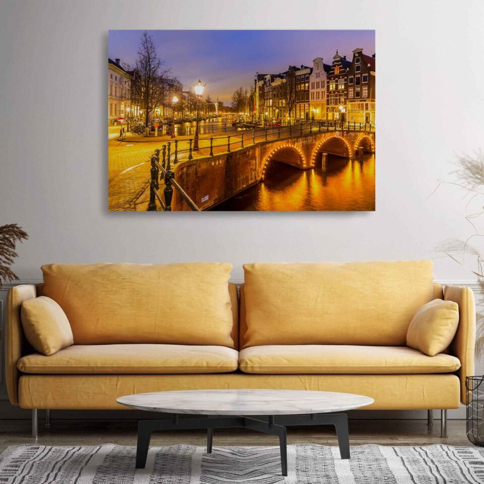 Serenity in Amsterdam - Canvas Art -  Sunset Reflections on the Amsterdam Canals. The image transports you to the charming streets of Amsterdam, where historic buildings line the water's edge, gracefully reflected in the calm and serene canal. The captivating colors and gentle ripples of the water create a tranquil atmosphere, evoking a sense of peace and tranquility.